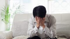 ソファで落ち込む男性